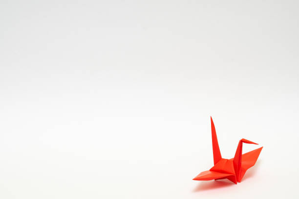 istock red origami paper crane on white background 1158778996
