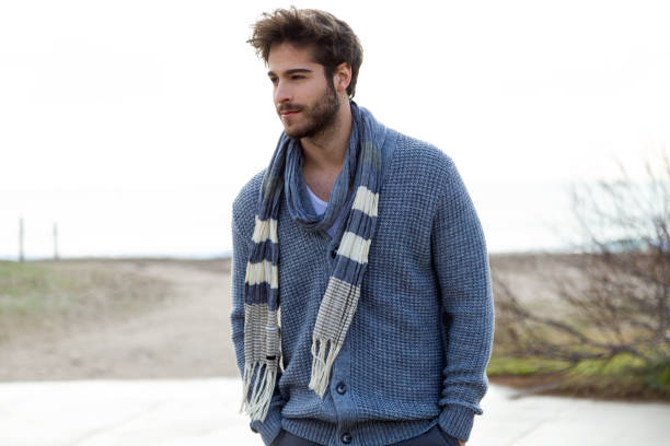 istock Handsome young man posing in a cold winter on the beach. 1158779032