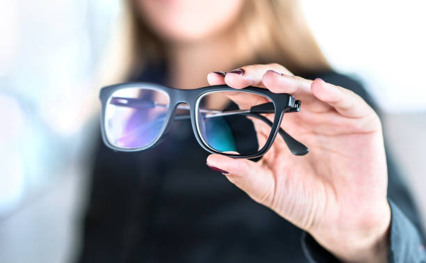 Optician, optometrist, oculist or eye doctor holding glasses and specs with new lenses. Professional eyesight specialist in clinic or shop with spectacles in hand. stock photo