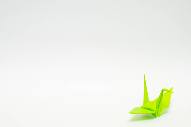 istock light green origami paper crane on white background 1158779237