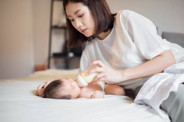 la neonata beve latte da sua madre - sucking asian ethnicity baby mother foto e immagini stock