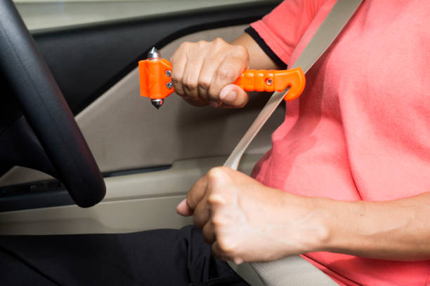 as mulheres usam o martelo da segurança e o cortador do seatbelt nos carros, correia cortada quando emergência. - broken window glass women - fotografias e filmes do acervo