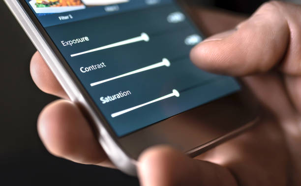 Photo edit with mobile phone and smart app. Man adjusting sliders. Image editing, manipulation, improvement or enhancement with smartphone. Photo edit with mobile phone and smart app. Man adjusting sliders. Image editing, manipulation, improvement or enhancement with smartphone. Adding filter to photograph in social media application. retouching stock pictures, royalty-free photos & images