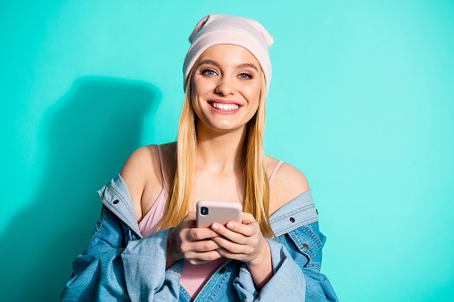 Close-up portrait of nice attractive lovely sweet cheerful cheery girl wearing streetstyle using app 5g device gadget modern technology isolated over bright vivid shine blue green turquoise background