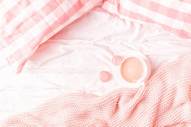 istock Bed with pink knitted plaid, coffee and macaroons 1158782110