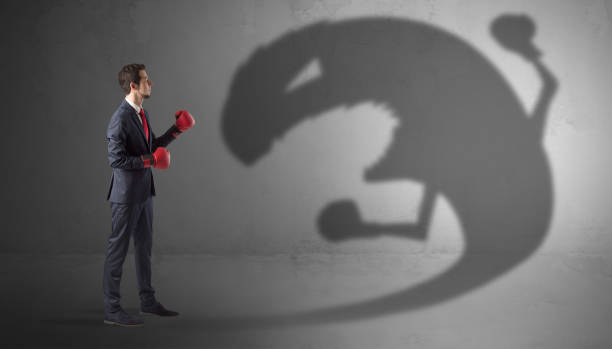 istock Businessman fighting with a big monster shadow 1158782227