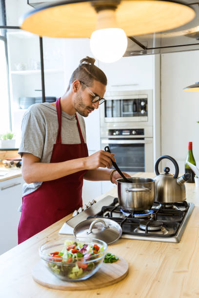 istock Handsome young man cooking in the kitchen at home. 1158782360