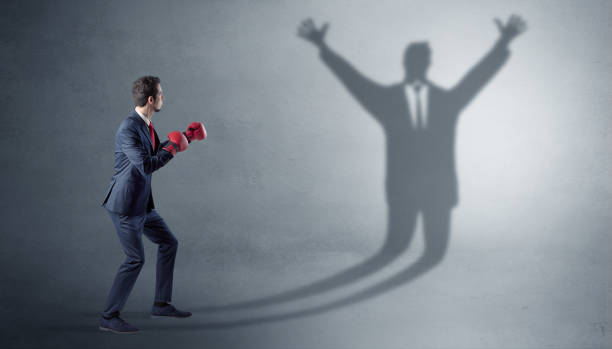 istock Businessman fighting with a disarmed businessman shadow 1158782868