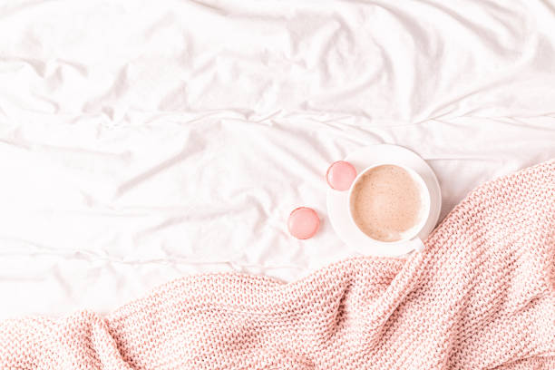 istock Bed with pink knitted plaid, coffee and macaroons 1158782899
