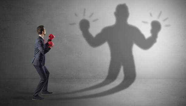 istock Businessman fighting with his unarmed shadow 1158783555