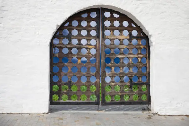 Old carved door in the white wall. One of the entrances to the Tobolsk Kremlin. Kemerovo region. Russia.