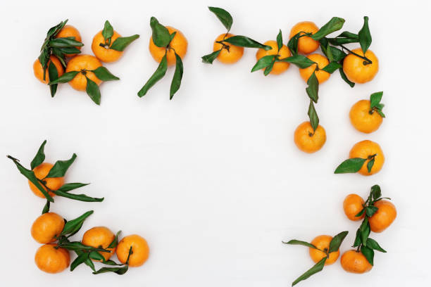 istock Tangerines with green leaves on white  background. Frame from ripe tangerines. 1158786836