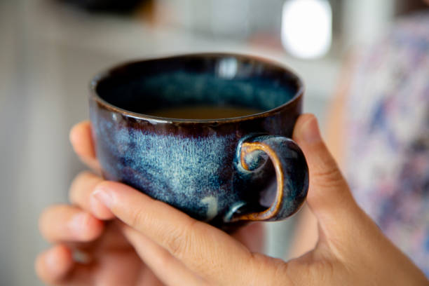 istock hand holding porcelain coffee cup 1158787007