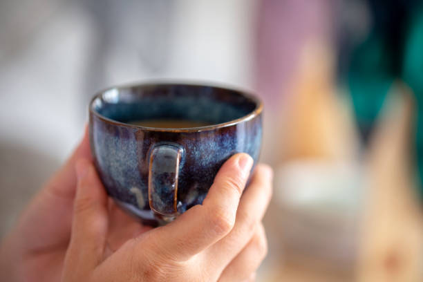 istock hand holding porcelain coffee cup 1158787026