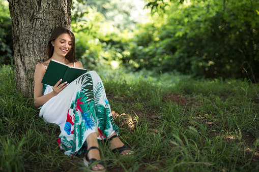 Beutiful smiling woman reads a book