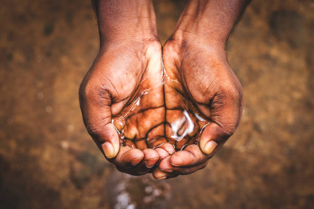 un homme retenant l'eau dans sa main, économisez l'eau, crise d'eau en inde et dans le monde entier - water crisis photos et images de collection