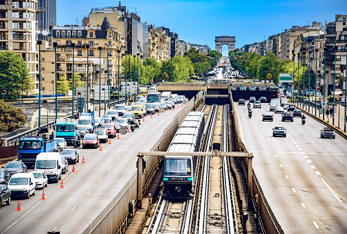 Paris traffic with roadworks viewed from La Defense toward Arc De Triomphe, car vehicles, metro train rush hour