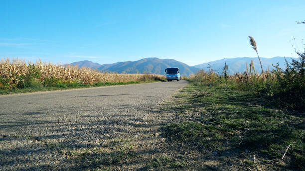 田舎の田舎道を通るヴィンテージバン�バスドライブ - pullman car ストックフォトと画像