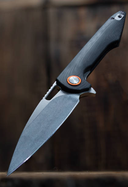 istock Folding knife on a wooden background. Knife at an angle. 1158793942