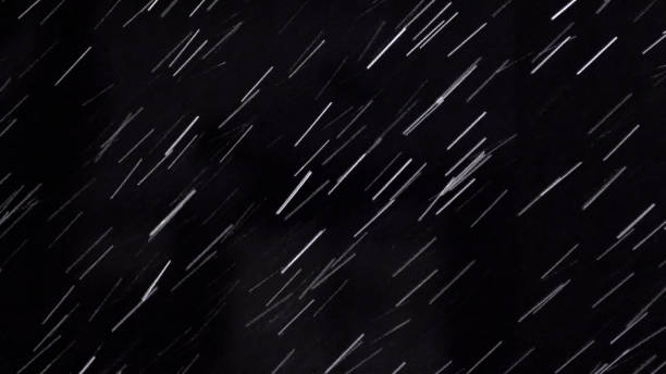 istock Heavy rain drops on night black background with light. It can be used as luma matte for video production 1158794552