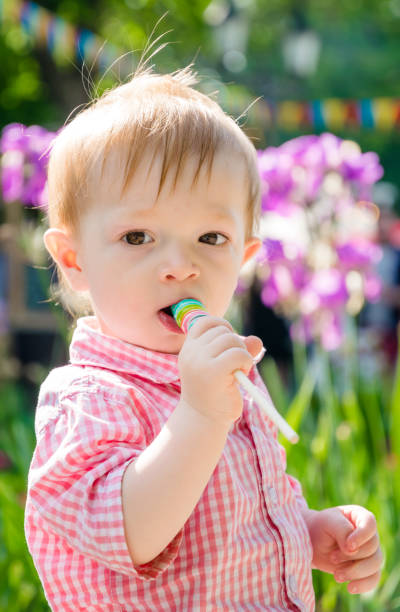 istock little boy eats a lollipop at a children's holiday 1158795977