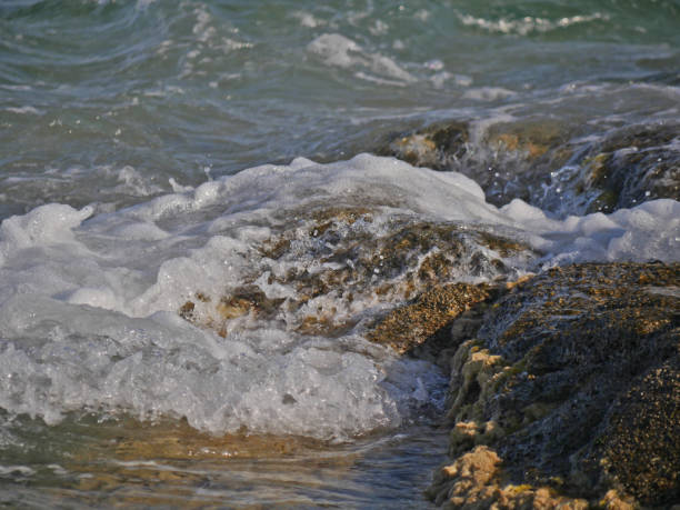 istock Waves crashing against the rock 1158798327