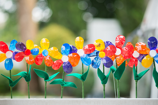 Recycled colorful plastic flowers in pot.
