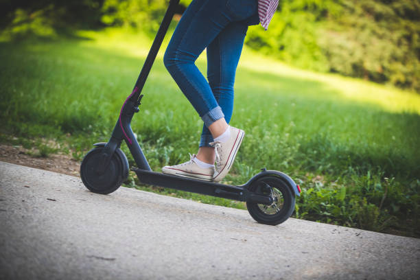 istock Woman riding motor scooter at park 1158803246