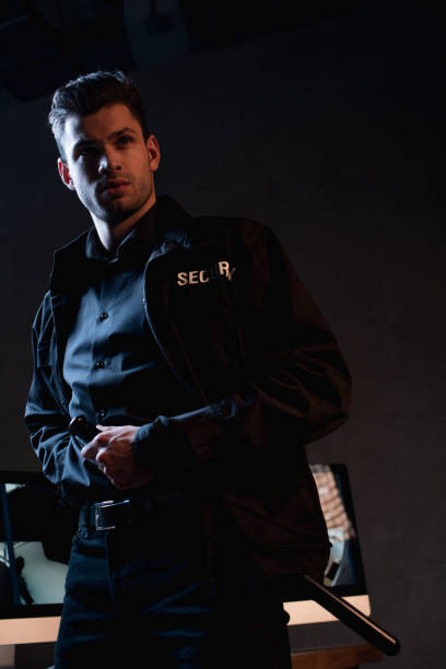 istock handsome guard in uniform standing and looking away 1158805546