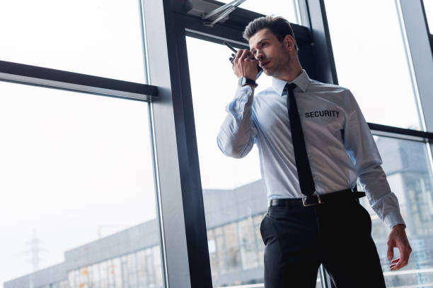 istock handsome guard in suit talking on walkie-talkie 1158805551