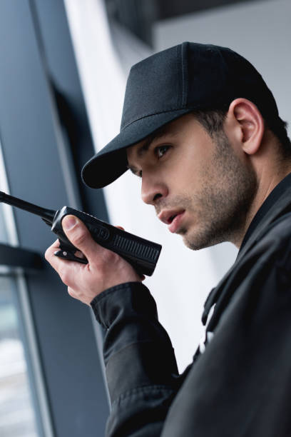 istock close up of guard in black uniform using walkie-talkie 1158805559