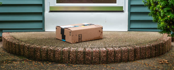 Package left out in the rain exposed on a front porch A package is delivered and placed on a wet stoop in the rain in the front of a house exposed to the elements and theft by a delevery service. front porch stock pictures, royalty-free photos & images