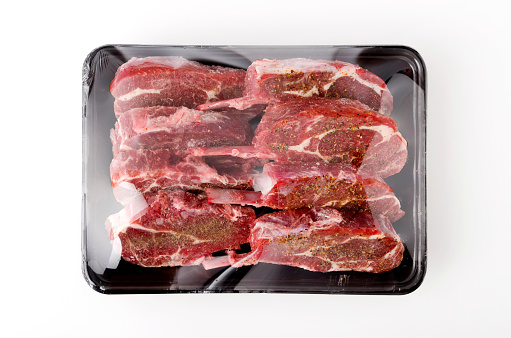 Packing raw Raw lamb chops on white background