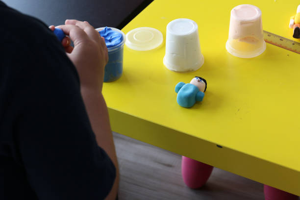 istock sculpted blue human play dough on yellow table 1158808243