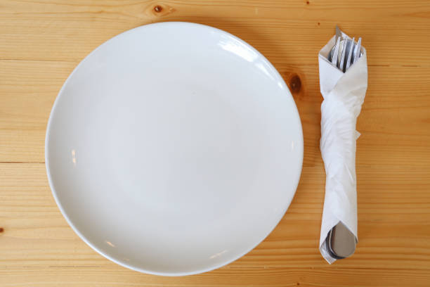 istock White empty dish  white napkin wrap cutlery on wood table 1158808268