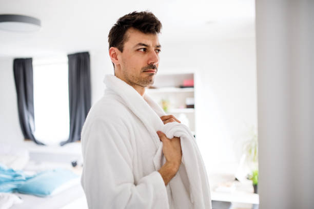 istock Young man with bathrobe in the bedroom, a morning routine. 1158808610