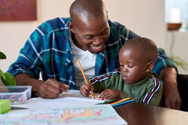 istock Dad watching his son drawing coloring books 1158810587