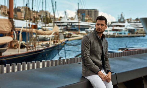 istock Young handsome man wear gray jacket and relaxing in harbor 1158811441