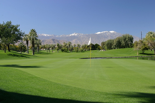 Golf course with snow on mountains