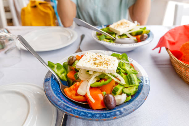 salade grecque au fromage feta dans une assiette au restaurant - cucumber vegetable close up fruit photos et images de collection