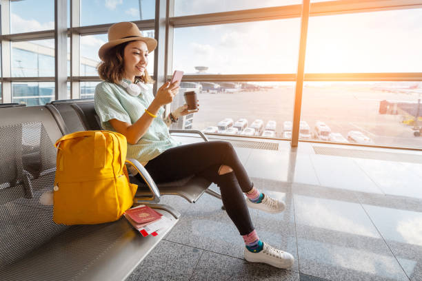 여권과 수하물공항에서 비행기를 기다리는 행복한 아시아 여성. 휴가 및 여행 개념 - airport 뉴스 사진 이미지