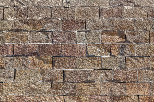 Old castle stone wall texture background. Old castle stone wall texture background. Brick backdrop brown color. roughhewn stock pictures, royalty-free photos & images