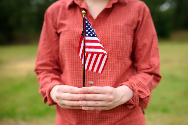 молодая женщина, держащая американский флаг. концепция дня независимости. - махать моделью стоковые фото и изображения