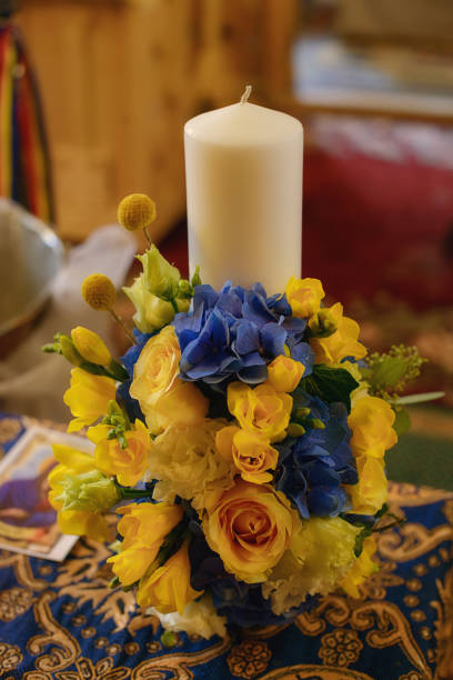 istock Baptismal candle decorated with a yellow spring flowers bouquet 1158814440