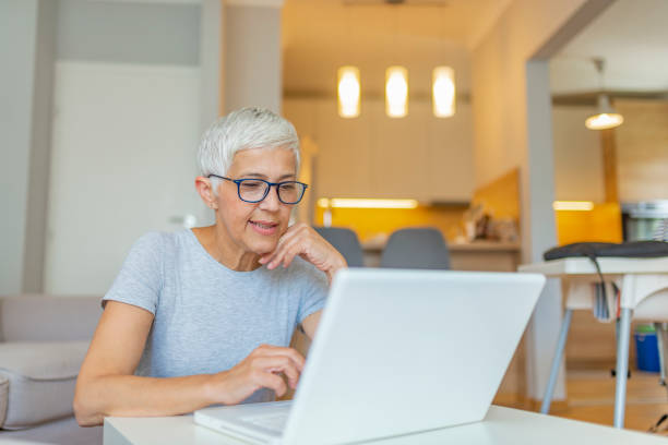 istock Elderly woman working on laptop computer, smiling. 1158815222
