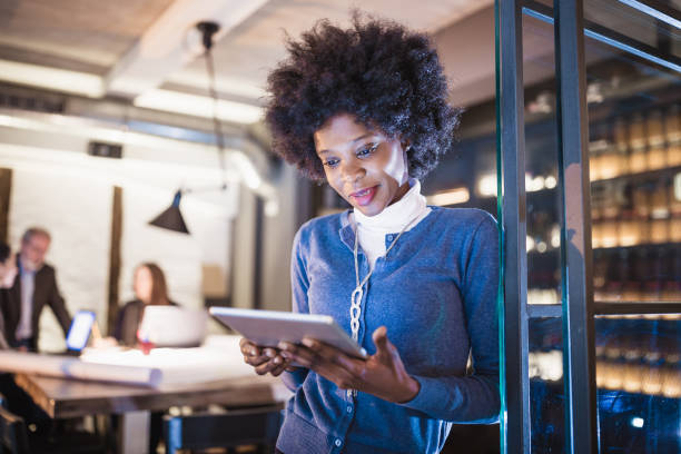 istock Young African-American woman architect using digital tablet in front of architecture studio. 1158816112
