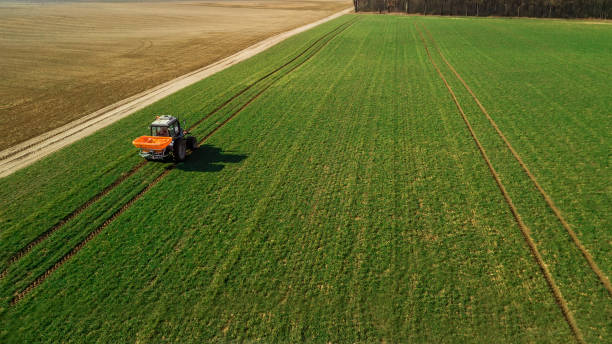 istock tractor makes fertilizer on the field. Aerial survey 1158816487