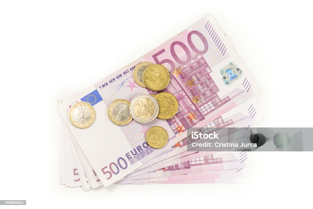 Stack of Euro banknotes and coins isolated. 500 Euro banknotes. European currency money banknotes isolated on white backdrop. Top view closeup. Salary, savings, european union economic crisis concept. Bank - Financial Building Stock Photo
