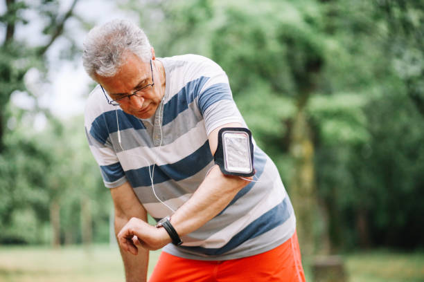 istock Active senior man exercising in nature, checking smart watch 1158818419