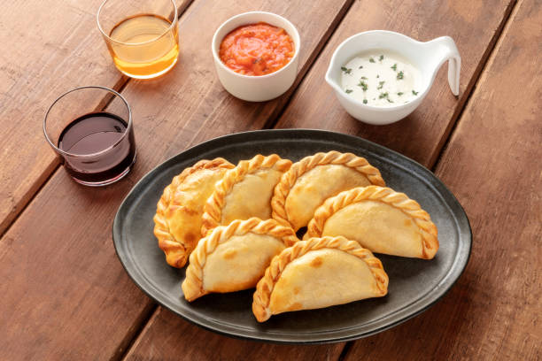istock Empanadas with sauces and wine on a dark rustic wooden background 1158819694